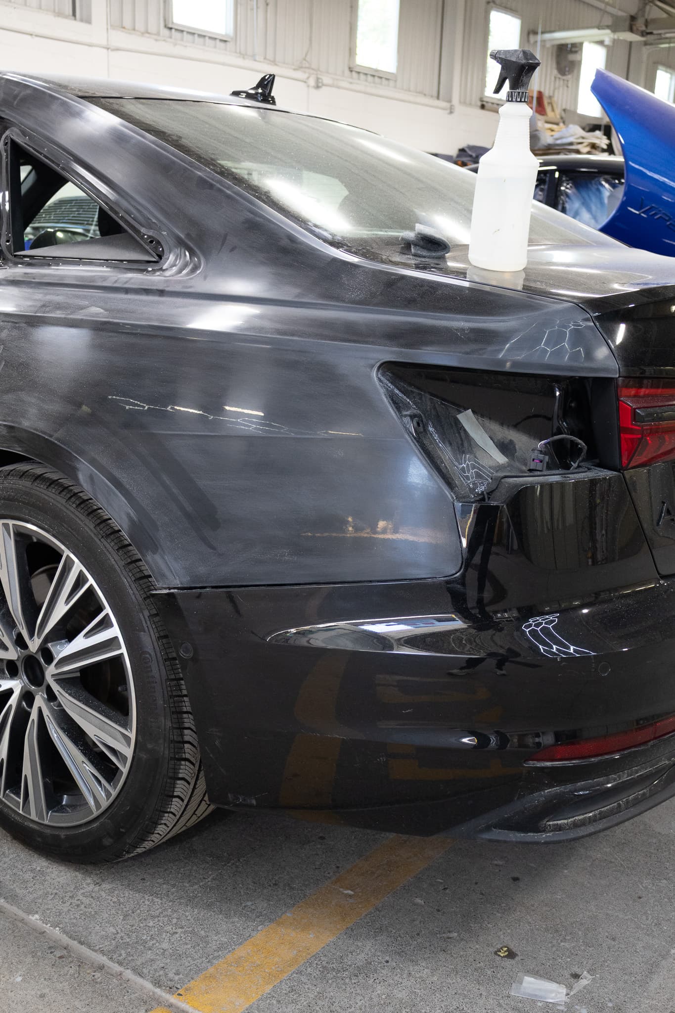 Black Audi with rear-quarter collision damage at Autometric Body & Paint in Pontiac, MI